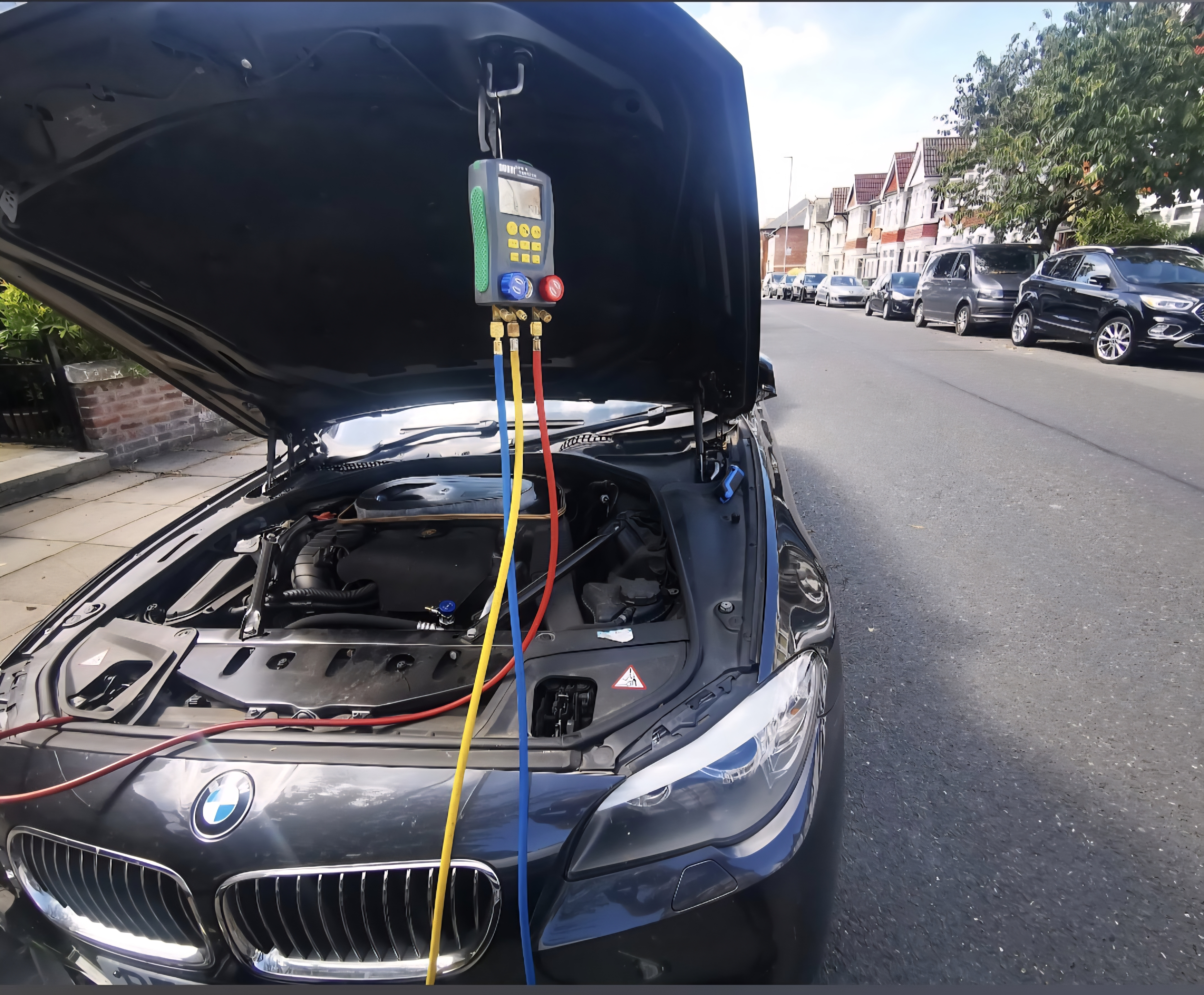 Black BMW AC service with digital manifold pressure tester connected